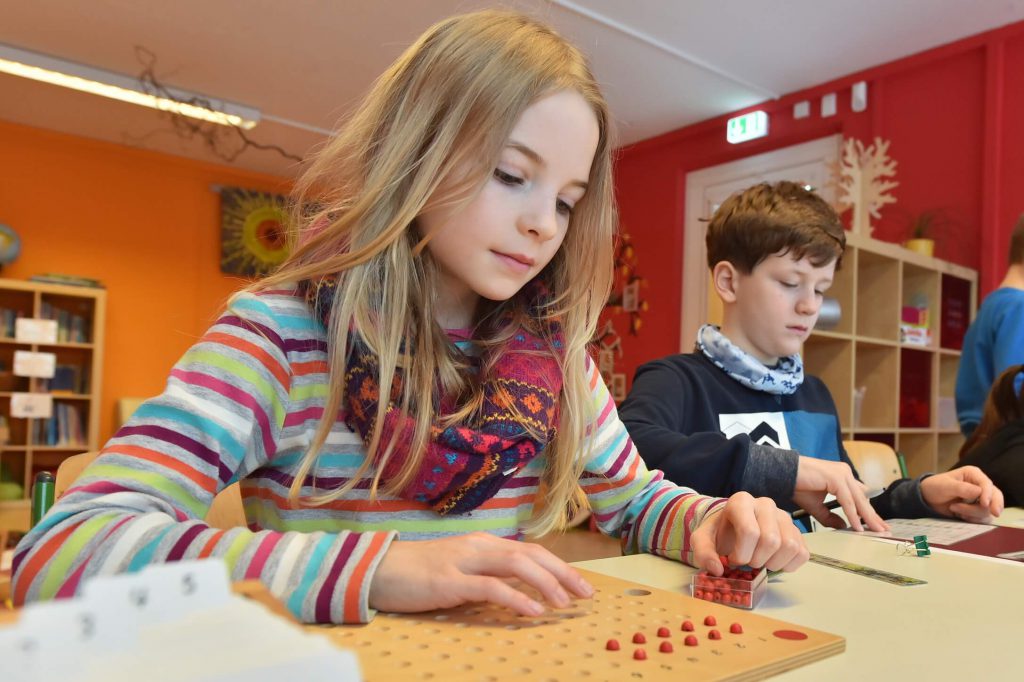 Hier sehen Sie zwei Schüler, die an einem Tisch sitzen und lernen.